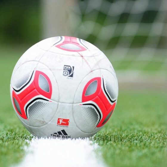 Balón de fútbol en línea de gol como símbolo del deporte popular